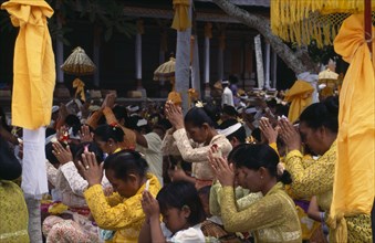 INDONESIA, Bali  , Kuningan Festival. Mas women dressed in yellow at Pura Taman Pule Temple