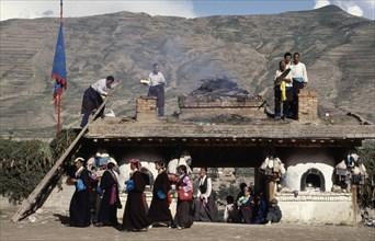 CHINA, Quinghai, Burning Juniper and other offerings at a Temple entrance during a Tibetan festival