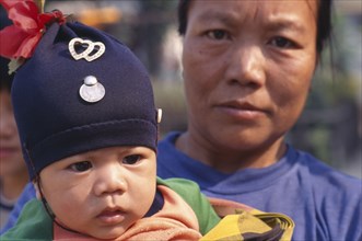 THAILAND, North, Chiang Mai Area, Close up portrait of Karen refugee mother and baby