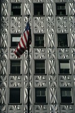 USA, New York, Manhattan, American flag flying in front of building with aluminium facade