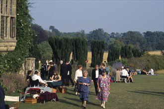 ENGLAND,  East Sussex, Glyndebourne, Opera attendees enjoying picnics in the gardens during
