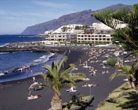 SPAIN, Canary Islands, Tenerife, Playa de la Arena near Los Gigantes with sunbathers on black sandy