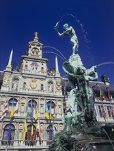 BELGIUM, Antwerp, Town Hall facade decorated with flags and the Brabo Fountain in the foreground