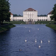 GERMANY, Bavaria , Munich, Schloss Nymphenburg. Viewed from tree lined canal with swans and ducks