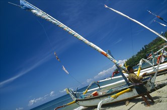 INDONESIA, Lombok, Senggigi, Outrigger sailboats on the beach with fisherman