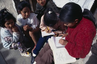 BOLIVIA, Potosi, Children doing homework on street