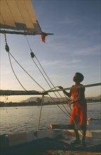 EGYPT,  , Transport, Felucca on the River Nile in the evening with young boy adjusting rigging