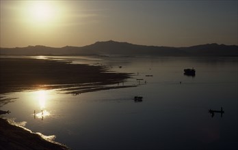 Myanmar, Pagan, View over Irawaddy river at dusk or dawn with the sun in left corner reflecting off