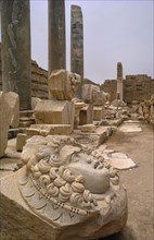 LIBYA , Leptis Magna, Roman ruins of the New Forum with carved face in the foreground and green