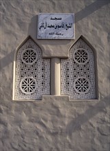 QATAR, Doha, Window detail of Small Mosque in the old souk area with sign in Arabic above it.
