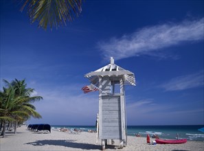USA, Florida , Fort Lauderdale, Lifeguard hut on occupied sandy beach with American flag flying
