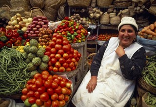 BOLIVIA,  , Sucre, Fruit and vegetable stall and smiling woman vendor.