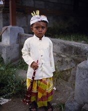 INDONESIA, Bali  , Mas, Young boy in traditional dress for Kuningan Festival