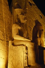 EGYPT, Luxor, The temple illuminated at night with the giant statues of Ramesses II outside The