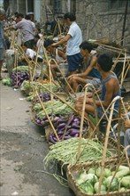 CHINA, Guizhou Province, "Village vegetable market, line of vendors selling beans and aubergines