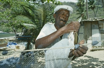 WEST INDIES, St.Lucia , Soufriere, Fisherman mending nets on the beach.