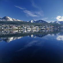 ARGENTINA, Tierra del Fuego, Ushuaia, The town of Bahia Ushuaia reflected in still water with