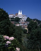 PORTUGAL, Estremadura, Sintra, "National Palace with twin roof towers, houses and trees beneath