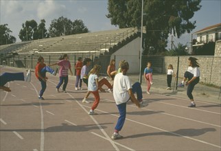 GREECE, Education, Exercise, Children performing warm up exercises on School track