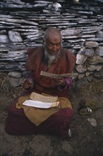 CHINA , Tibet , Drigling Til, Elderly man reciting mantras at sky burial