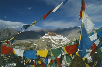 TIBET, Lhasa, Potala Palace, View across valley through prayer flags towards the Potala set on the
