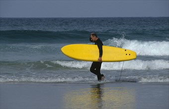 ENGLAND, Cornwall, Newquay, Surfer on Fistral Beach