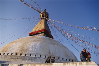 10072366 NEPAL Kathmandu Valley Bodhnath Part view of stupa hung with prayer flags and pilgrims.