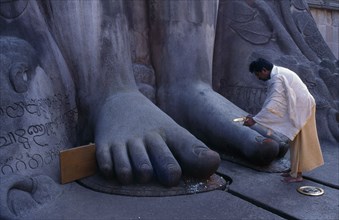INDIA, Karnataka, Sravanbelgola, "Jain Brahmin at feet of statue of Bahubali, the Gomateshvara."