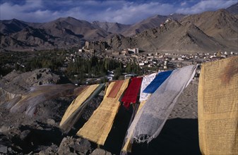 INDIA, Ladakh , Leh , View over Leh Valley and town from hill-top with line of prayer flags flying