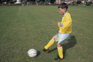 SPORT, Ball Games, Soccer, Young boy kicking football.