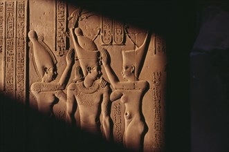 EGYPT,  , Komombo, Relief carving of three figures and hieroglyphics In shadow