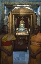 SRI LANKA, Kandy, Temple of The Tooth. Guardians of the Tooth standing outside the room holding the