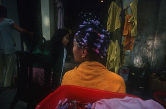 VIETNAM, Hanoi , Woman standing facing the other way with curlers in her hair