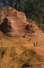 FRANCE, Provence Roussillon, Ochre quarry , "People walking through the yellow, brown landscape."