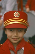 CHINA, Sichuan Province, Chengdu,  Portrait of young Boy in band wearing red and gold hat