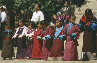 CHINA , Relgion, Festival, Line of Tibetan girls preparing to dance at festival