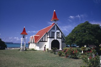 MAURITIUS, Cap Malheureux, Red and white chapel with garden in the foreground and the sea behind