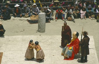 TIBET, Samye Monastery, Clowns performing at a Full Moon Festival with onlookers.