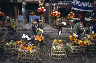 CHINA, Sichuan, Chengdu, Vendors sitting with displays at the Flower Market