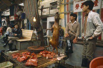 CHINA, Guangdong Province, Guangzhou , Dog meat for sale on street stall.