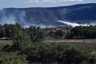 FRANCE, Provence Cote d’Azur, Luberon , Firefighter Plane flying towards smoke from a forest fire