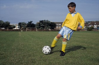 SPORT, Ball Games, Soccer, Young boy kicking football.