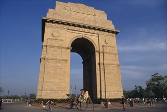 INDIA, New Delhi, India Gate.  Man leading camel past carrying three children
