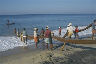 INDIA, Kerala , Varkala, Fisherman landing fish on beach.