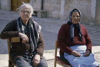 ITALY, Apulia , Two elderly women sitting on chairs in street