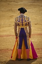 SPAIN, Andalucia , Seville , Matador in bull ring with cape covering his legs