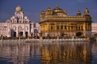 INDIA, Punjab, Amritsar, The Golden Temple reflected in rippled surface of pool.