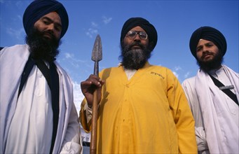 INDIA, Punjab, Amritsar, Three-quarter portrait of three of the guardians of the Golden Temple.