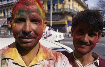 INDIA, Delhi , Two men covered with powder paint dyes during Holi Festival