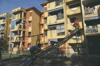 INDIA, Uttar Pradesh , Delhi, New housing estate with children playing on a slide in the foreground